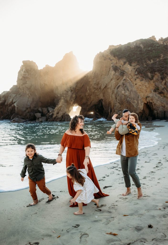family playing on Pfeiffer beach in Big Sur