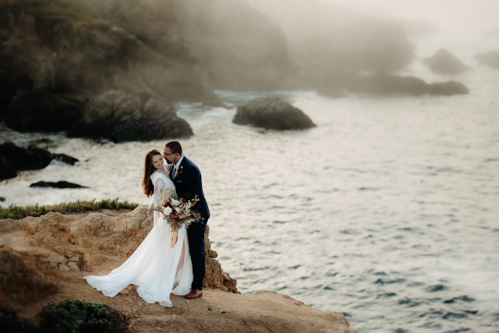 bride and groom on a foggy cliff in Big Sur